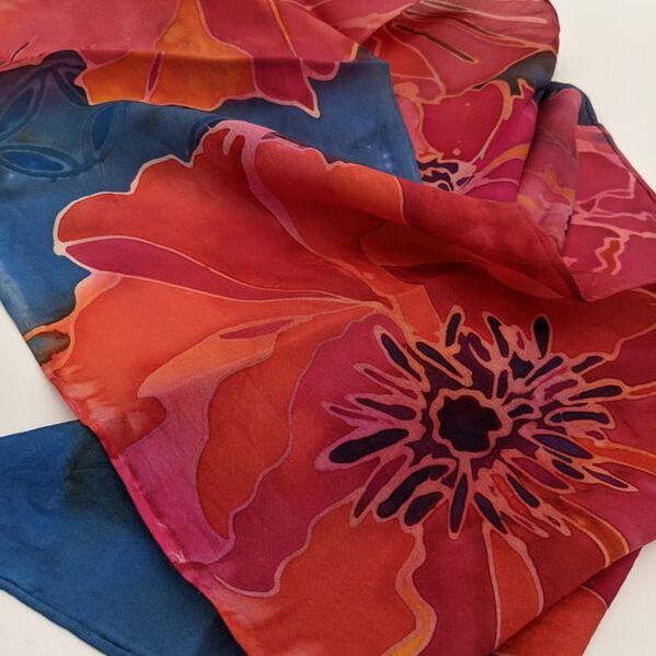 Close up detail of red poppy painted on silk scarf